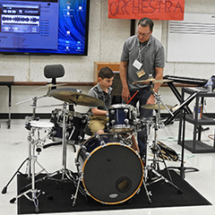 Kennan Wylie coaches 7th-grader Sam Schulz on the drumset